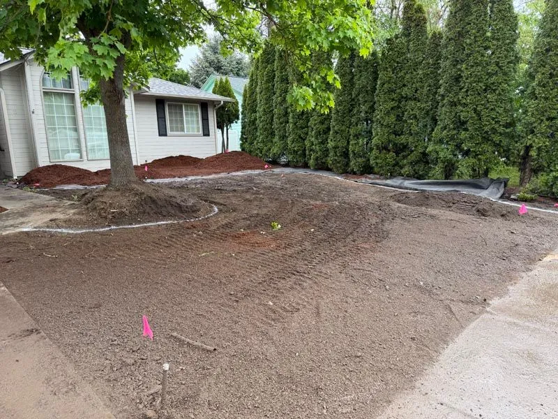 Front yard graded and prepped for sod next to a house